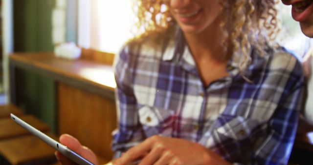 Friends Smiling and Using a Tablet in a Cozy Cafe - Download Free Stock Images Pikwizard.com