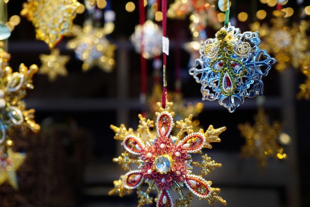 This vibrant close-up showcases intricately designed hanging Christmas ornaments adorned with embellishments. Ideal for use in holiday-themed marketing, advertisements, blog posts about Christmas decor, art and craft features, and social media posts spreading festive cheer. Perfect for representing holiday craftsmanship and the intricacies of seasonal decorations.
