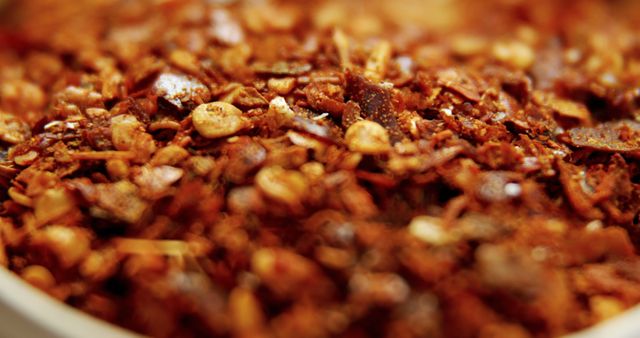 Close-up view of a granola mixture featuring various nuts and dried fruits. The texture and colors highlight the different components, suggesting a nutritious and delicious option for breakfast or a snack. Perfect for use in healthy eating blogs, food packaging designs, and marketing materials for nutritional products.