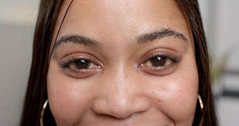Close-Up of Smiling African American Woman with Freckles and Hoop Earrings