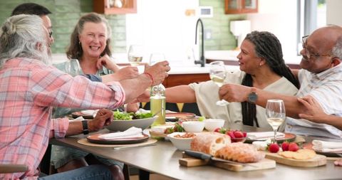 Diverse Senior Friends Celebrating with a Toast at Dinner Table