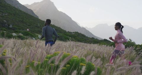 Diverse Couple Running in Scenic Countryside Landscape at Sunrise