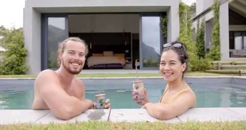Happy Couple Relaxing by Pool with Refreshing Drinks - Download Free Stock Images Pikwizard.com