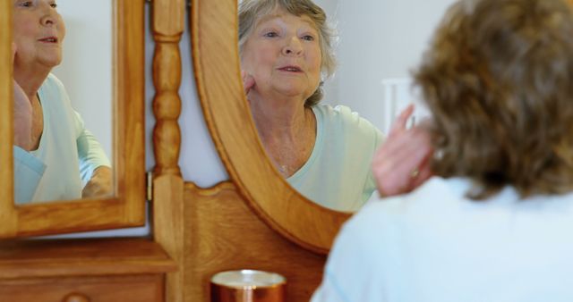 Senior Woman Applying Skincare While Looking in Mirror - Download Free Stock Images Pikwizard.com