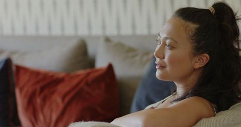 Bride sitting on sofa, serene reflection in elegant setting