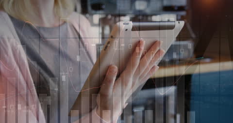 Businesswoman Analyzing Data on Digital Tablet with Growth Charts