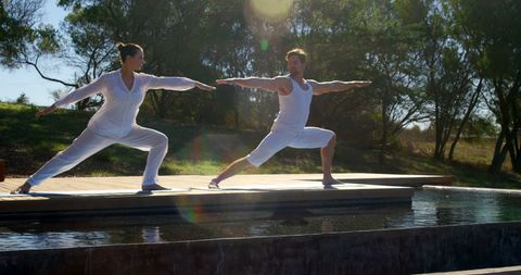 Healthy Lifestyle: Synchronized Yoga by Tranquil Water Outdoors