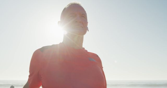 Senior Man Standing on Beach with Sunlight Backdrop - Download Free Stock Images Pikwizard.com