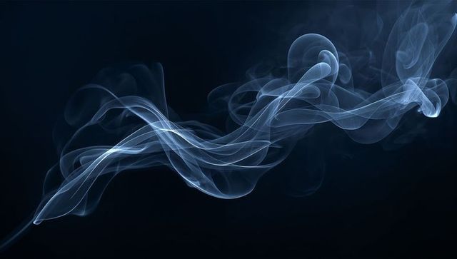 Ethereal blue-gray smoke ribbons weaving across dark backdrop for abstract vapor design