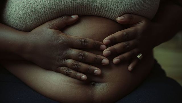 Expecting mother and partner embrace baby bump in intimate embrace