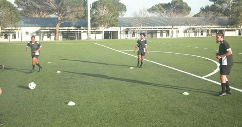Teen soccer players practicing passing drills on school field
