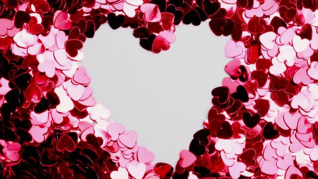 Vibrant depiction of a heart formed in the center of countless pink and red confetti pieces, creating a sense of love and celebration. Perfect for Valentine's Day promotions, romantic designs, or festive invitations. Highlights themes of romance and passion.