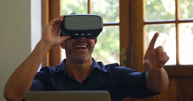 Happy man using VR headset in modern home environment - Download Free Stock Images Pikwizard.com