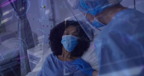 Clinician leaning at bedside comforting masked patient wearing ppe with vitals overlay