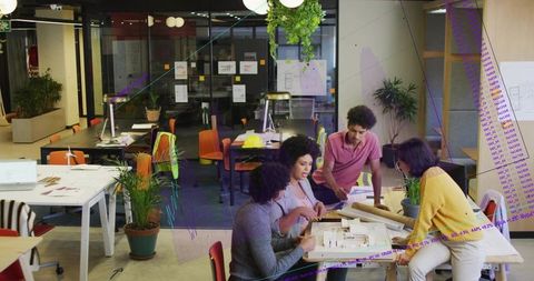 Collaborating Team Reviewing Architectural Scale Model and Blueprints in Bright Modern Studio Loft