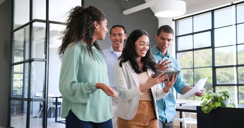 Diverse Office Team Discussing Work on Tablet Together