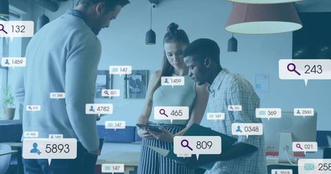 Young team collaborating over tablet with social metrics and analytics overlays in office