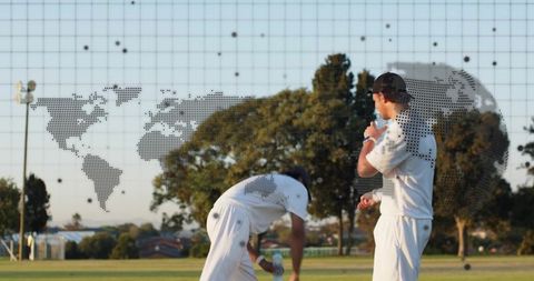 Cricketers taking water break in sunlit suburban park with dotted world map grid overlay
