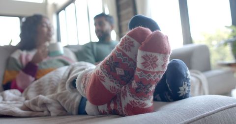 Cozy Couple Relaxing on Sofa with Warm Drinks