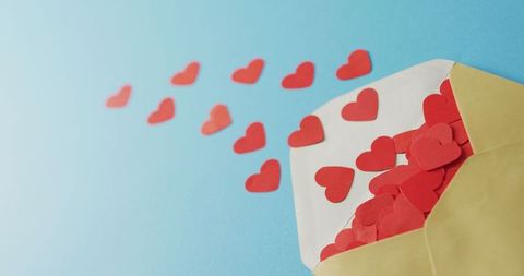 Crafted valentine hearts overflowing from envelope