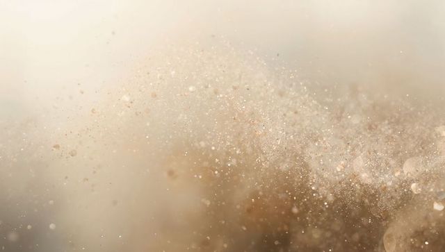 Ethereal golden dust cloud drifting in soft backlight with glitter bokeh and glow