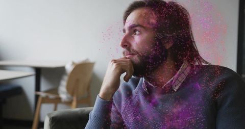 Contemplative man with dynamic particle effects in creative space
