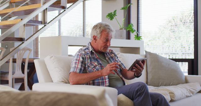 Senior Man Relaxing on Couch Using Digital Tablet at Home - Download Free Stock Images Pikwizard.com