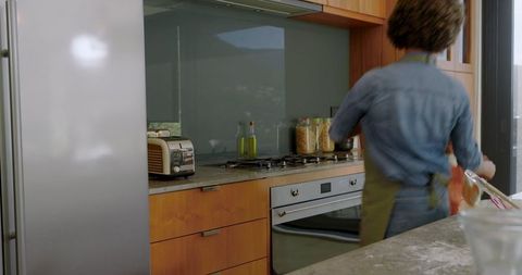 Modern rustic kitchen with female cook in action