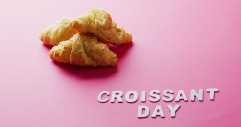 Celebrating croissant day with fresh pastries on pink