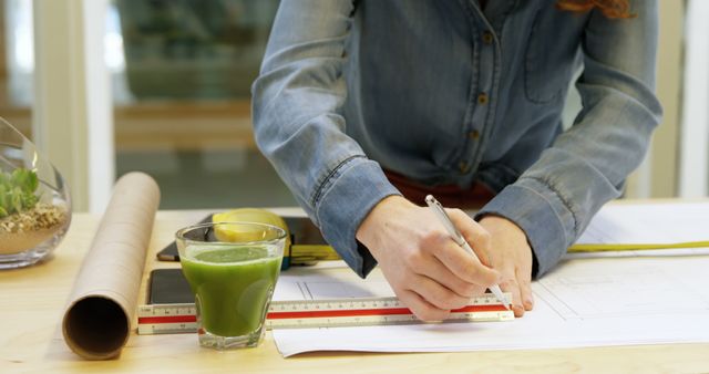 Architect drawing blueprint, green smoothie on desk - Download Free Stock Images Pikwizard.com