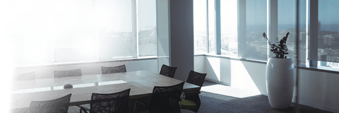 Transparent modern office space with large table and rolling chairs