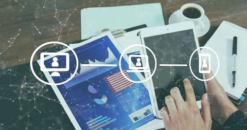 Hands tapping tablet and smartphone showing business analytics dashboard and network icons