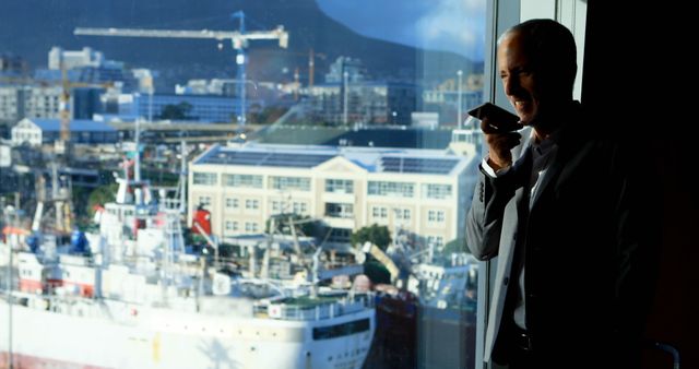 Businessman Making Phone Call in Urban Office Overlooking Industrial Harbor - Download Free Stock Images Pikwizard.com