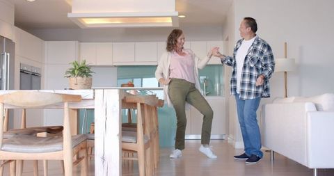 Happy Couple Dancing in Cozy Modern Kitchen at Home