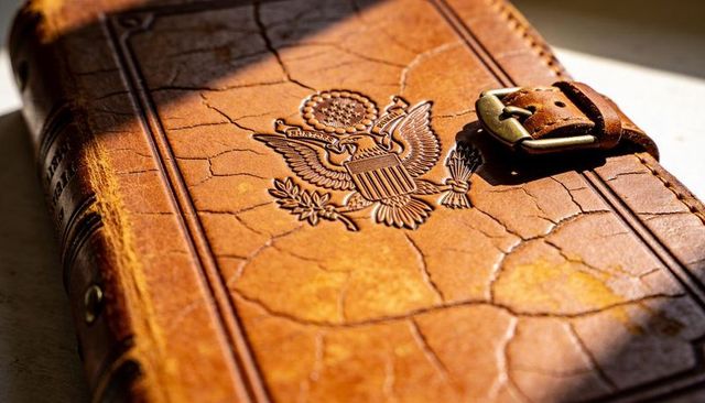 Vintage leather journal embossed eagle crest with brass buckle strap and cracked patina