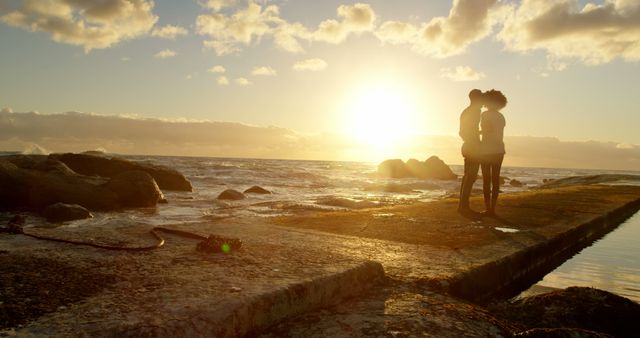 Romantic diverse couple standing and kissing on pier at sunrise, copy space. Summer, vacation, romance, love, relationship, free time and lifestyle, unaltered.