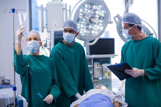 Surgeons Adjusting IV Drip in Operating Room - Download Free Stock Photos Pikwizard.com