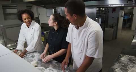 Chefs Talking and Preparing Dough in Busy Restaurant Kitchen