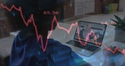Remote worker watching financial webinar with falling stock chart overlay on laptop