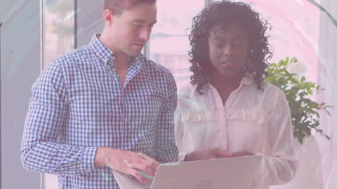 Diverse Colleagues Discussing Project on Laptop in Modern Office