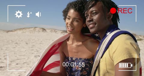 Interracial Young Couple with American Flag on Beach