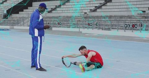 Athlete Adjusting Prosthetic on Track with Coach