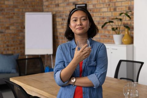 Confident Professional Woman Standing in Modern Office Meeting Room