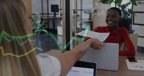 Smiling professional receiving report during collaborative data review in office
