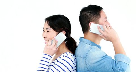 Smiling Young Adults Chatting on Smartphones