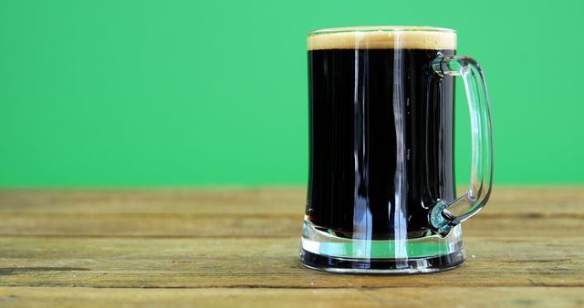 Perfect for marketing beer brands, pubs and breweries, advertisements for alcoholic beverages, and stock images for online articles about beer. Showcases richness of dark beer and captures rustic feel with wooden table contrasting bright green background.