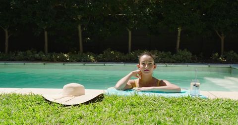 Woman Relaxing in Pool with Summer Essentials