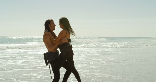 Caucasian couple enjoys a sunny beach day, with copy space. They share a romantic moment with the ocean as a backdrop.
