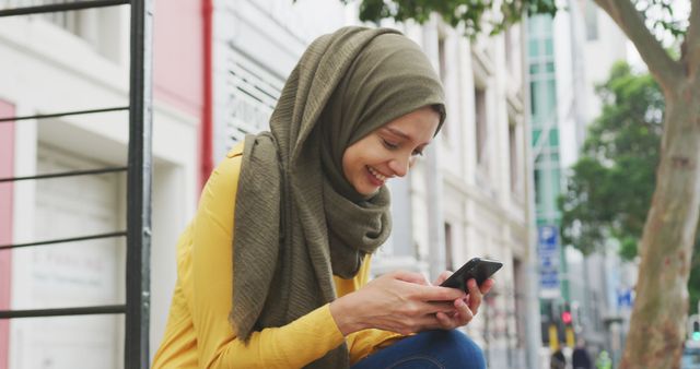 Smiling Muslim Woman Texting on Smartphone Outdoors in City, Wearing Hijab - Download Free Stock Images Pikwizard.com