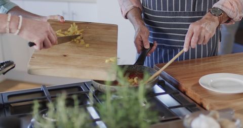 Middle-aged couple cooking together in cozy kitchen